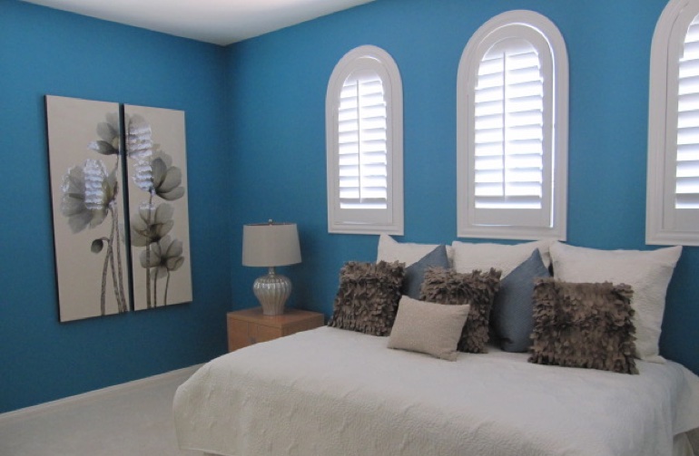 Bedroom with blue paint and white plantation shutters